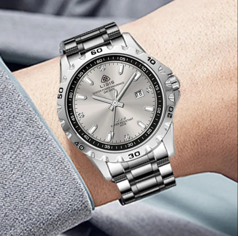 Men's silver case quartz watch with luminous hands on a grey stainless steel strap