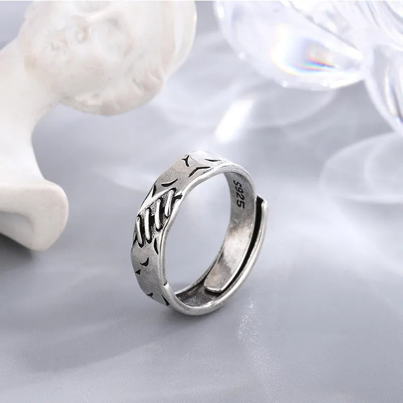 Black geometric adjustable ring with round and oval elements on copper base