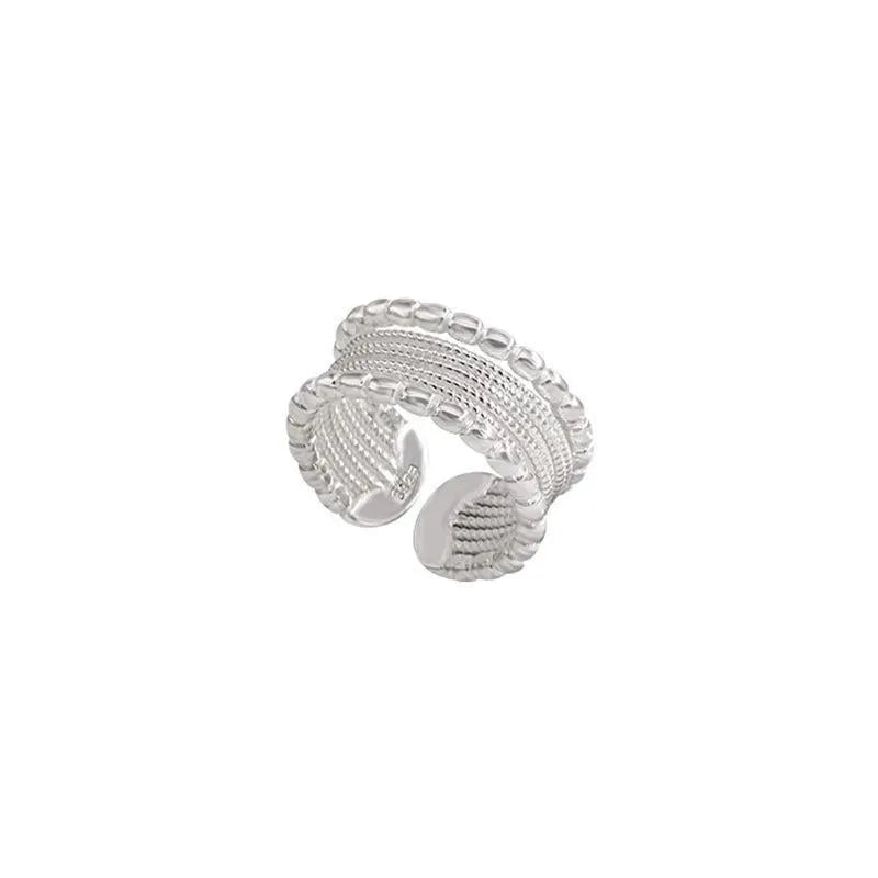 Copper geometric ring with woven twisted design and adjustable opening.