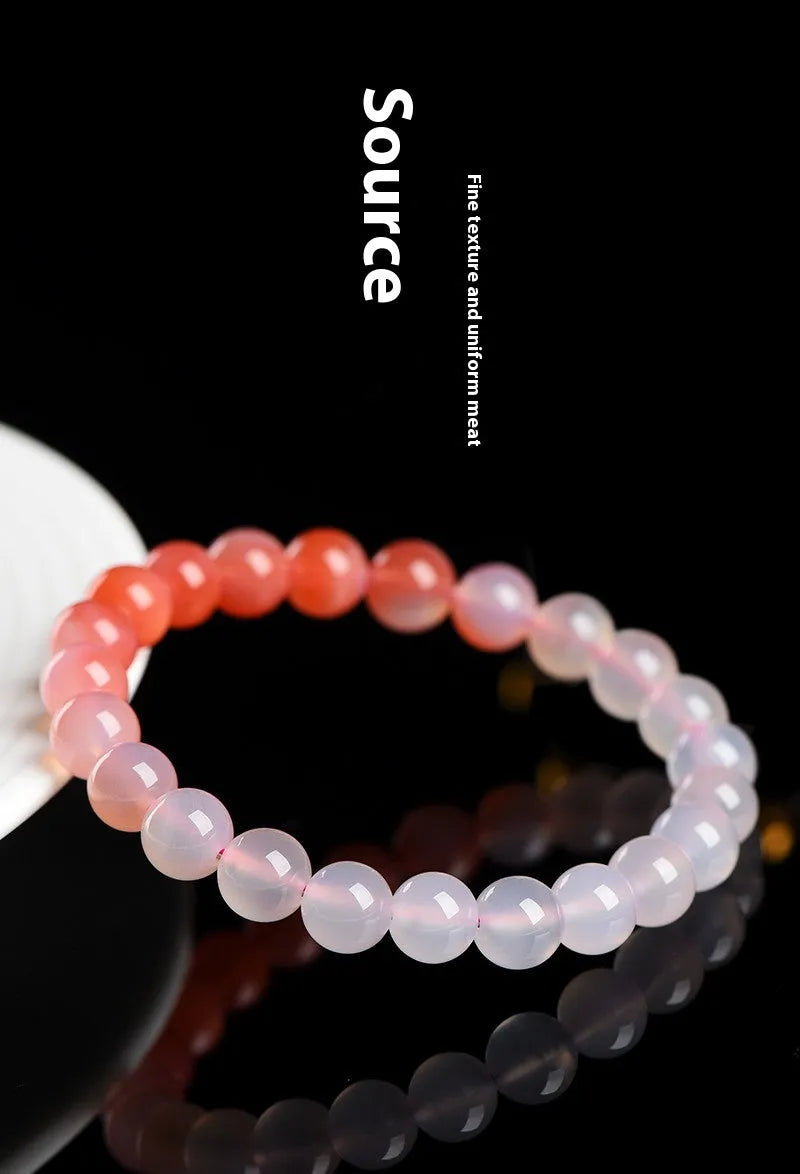 A gradient colour agate bead bracelet on a wrist, showing natural stone banding.