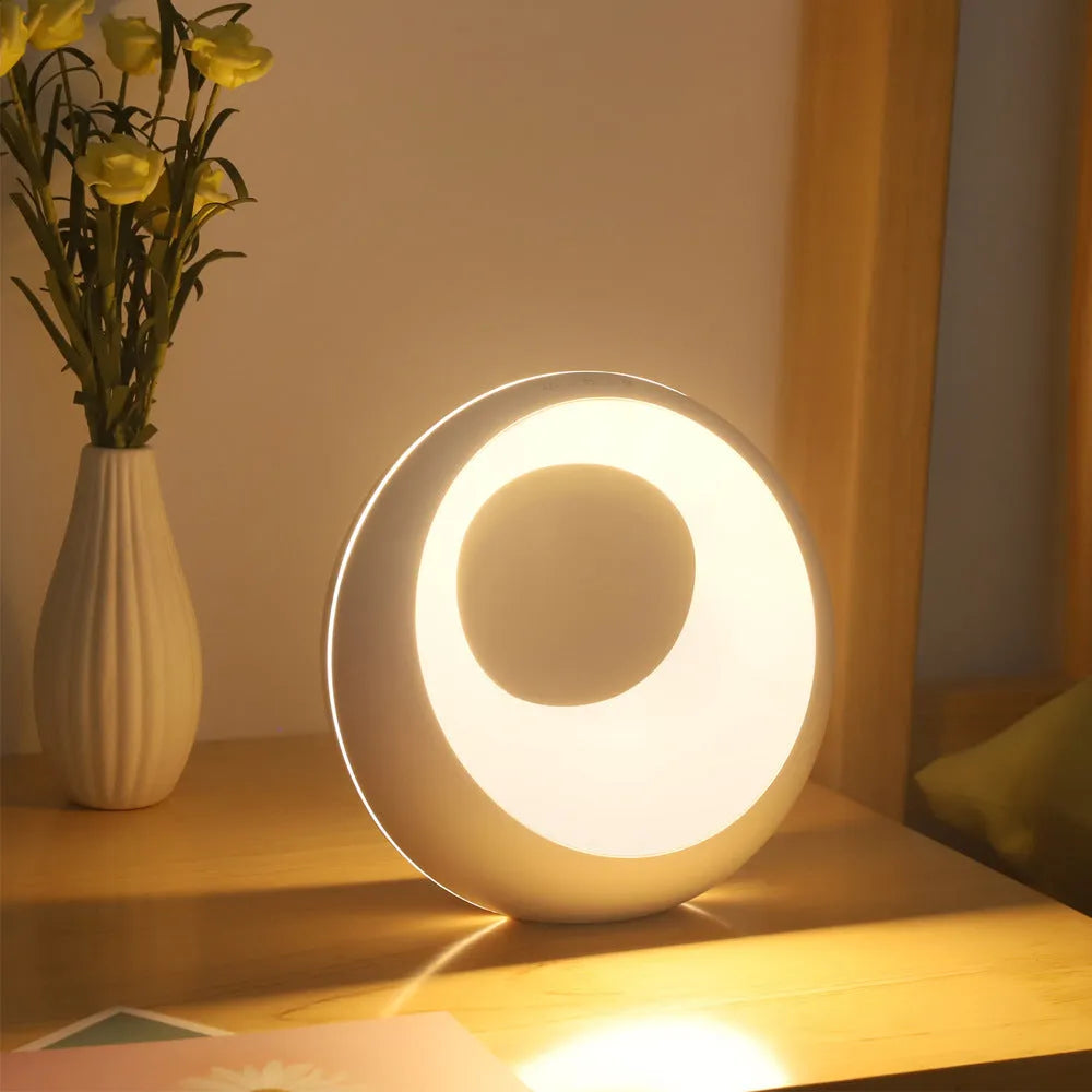 Small white RGB colour changing night lamp with remote control on wooden desk