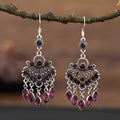 Purple drop-shaped earrings with long fringe detailing, showing retro ethnic style.