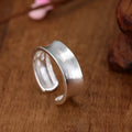 Open geometric ring in frosted sterling silver with an adjustable band.