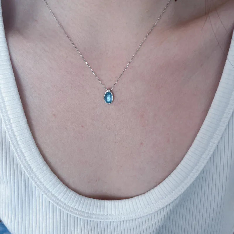 Navy blue water drop pendant necklace with platinum-colour finish on adjustable copper cross chain.