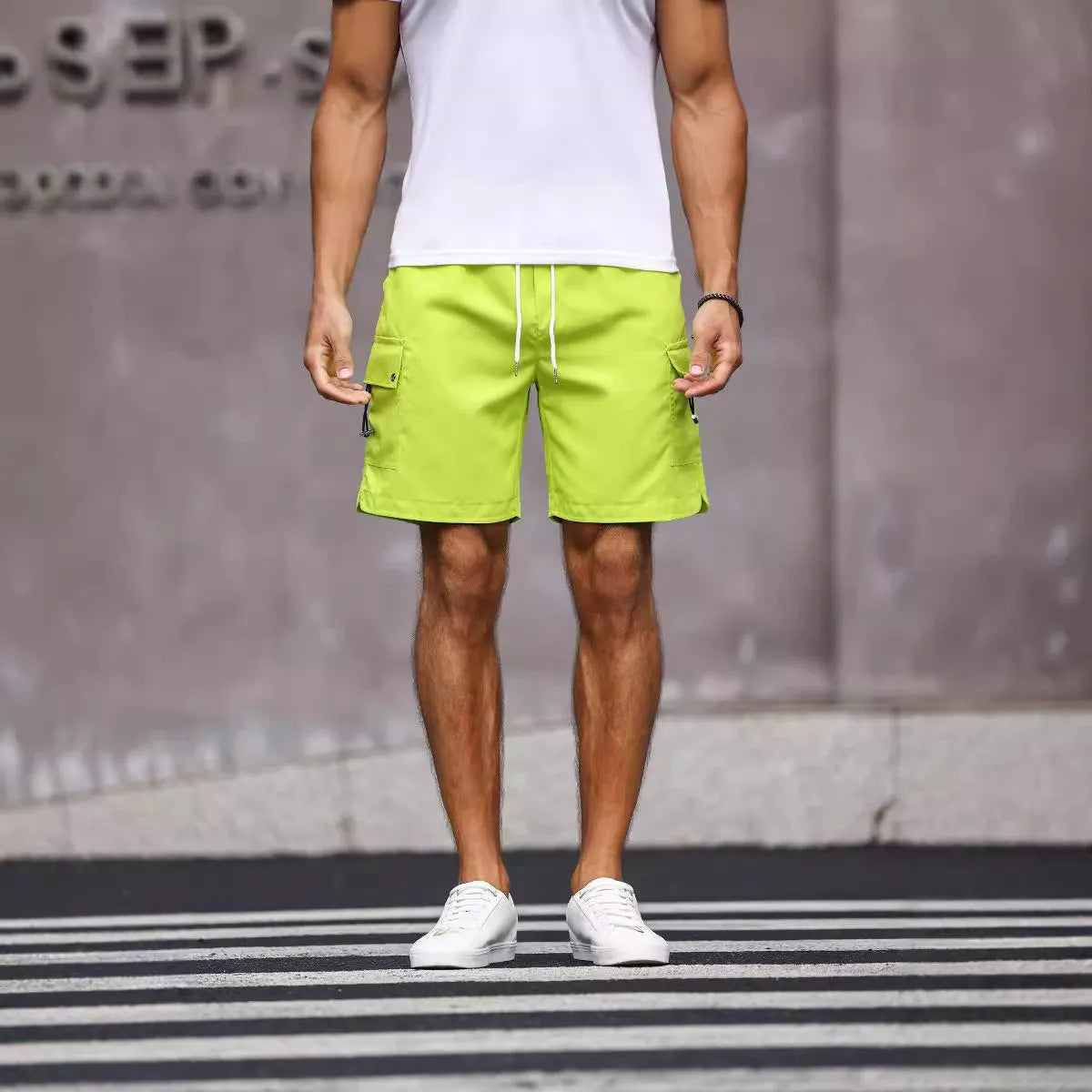 Men's loose fit workwear shorts in fluorescent green or army green with straight leg and fifth-pants length.