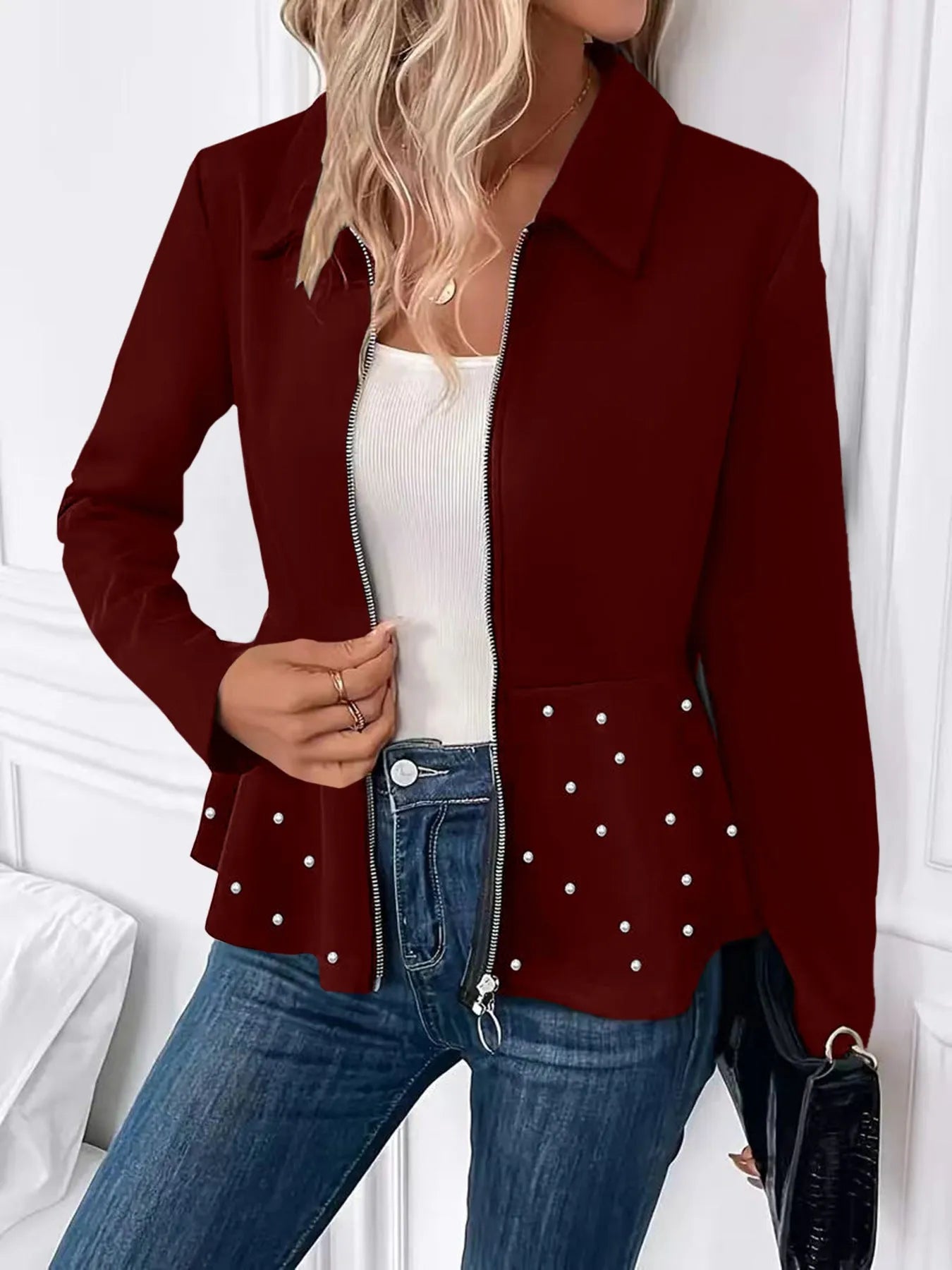 Women's loose fit black coat with a beaded zipper and ruffled hem detail on mannequin.