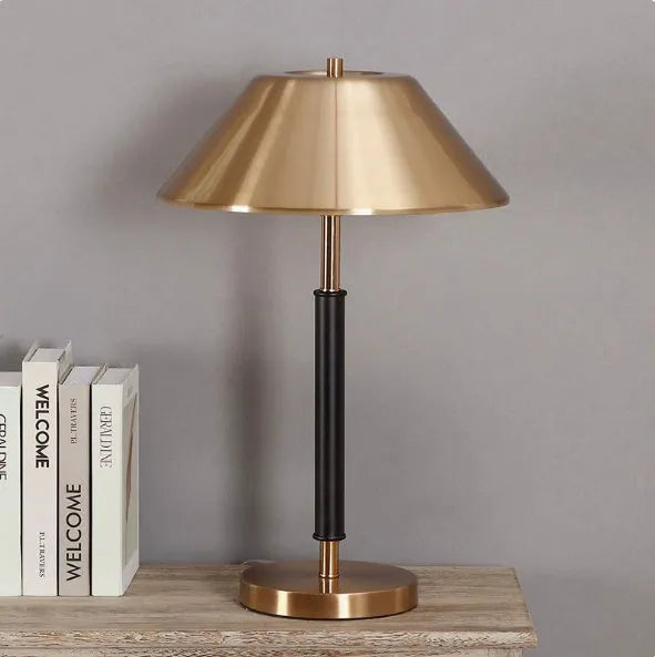 Post-modern metal bedside lamp with antique copper finish on a bedside table