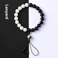 White and black bodhi seed bracelet with eight-diagram pattern, shown as a bracelet and lanyard.