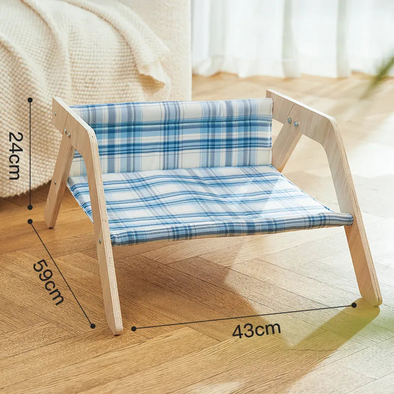 Blue elevated cat hammock bed with wooden beach chair frame on a white floor.