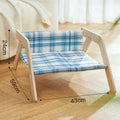 Blue elevated cat hammock bed with wooden beach chair frame on a white floor.