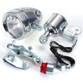 Silver bicycle dynamo generator light kit mounted on a bike frame with front and rear lights