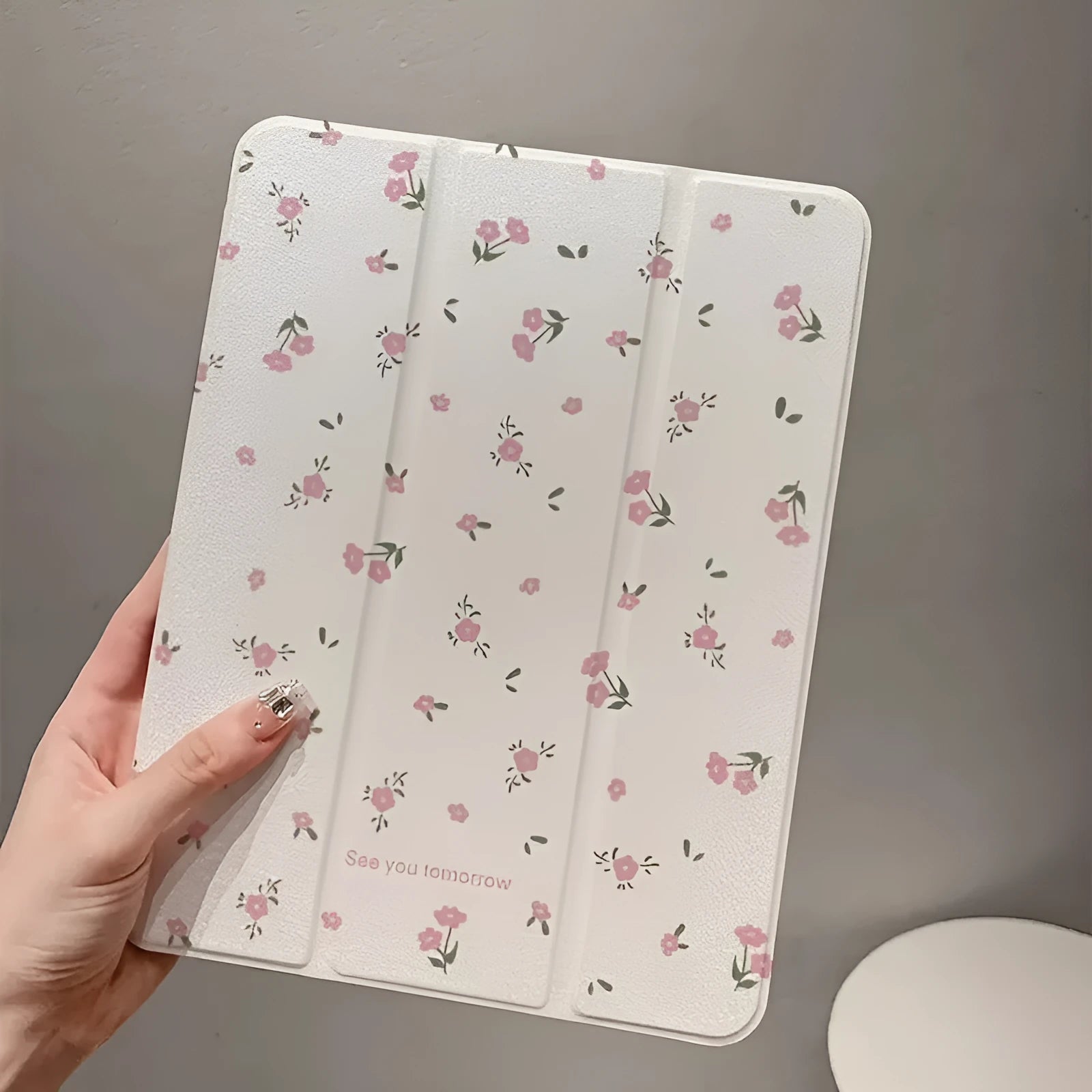 Transparent iPad case with floral cartoon pattern showing tri-fold stand position