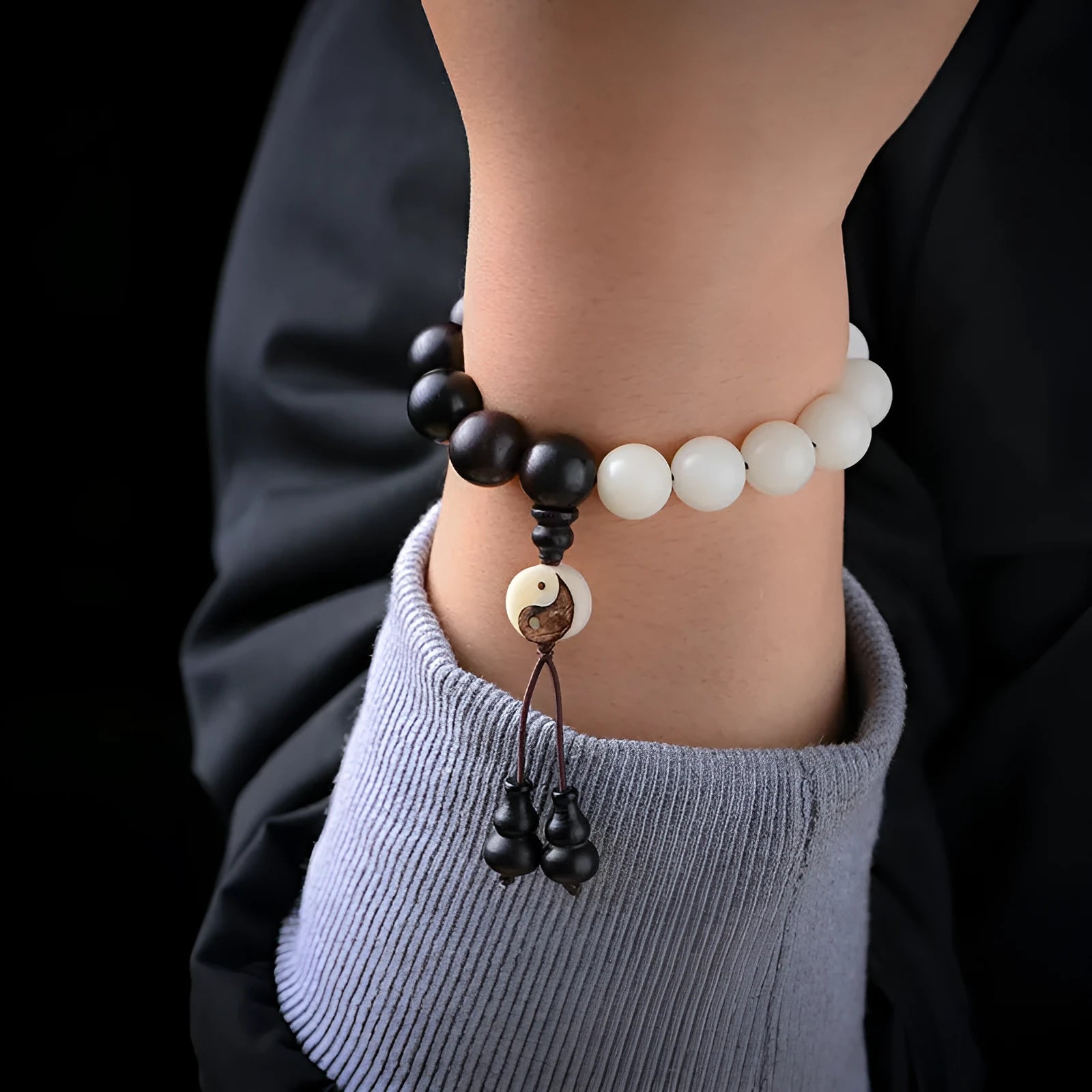 White and black bodhi seed bracelet with eight-diagram pattern, shown as a bracelet and lanyard.
