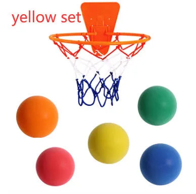 Assortment of bright coloured silent foam basketballs with a basketball frame on a neutral background