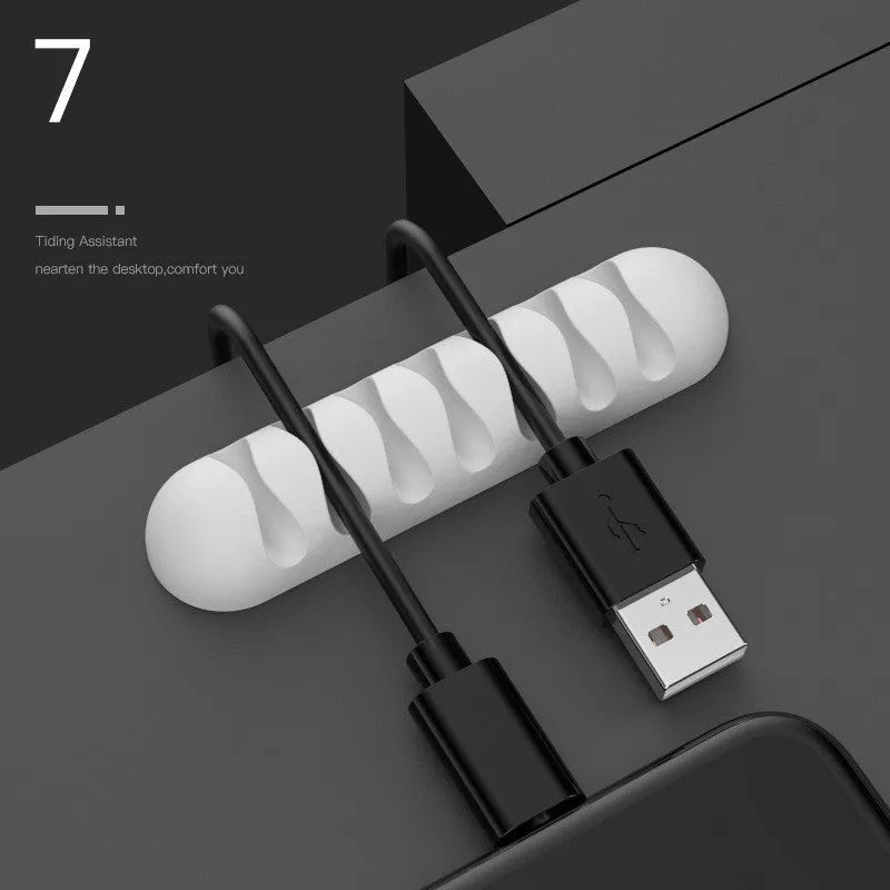 Smart cable holder with TPR flexible clips in black holding USB earphone and network cables on a desk