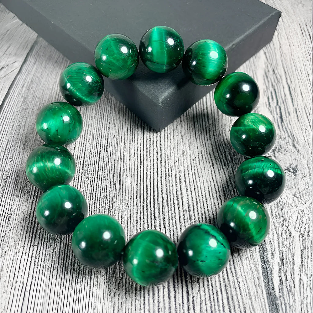 Green tiger eye stone bracelet with polished geometry beads and a sliding knot closure on a wrist.