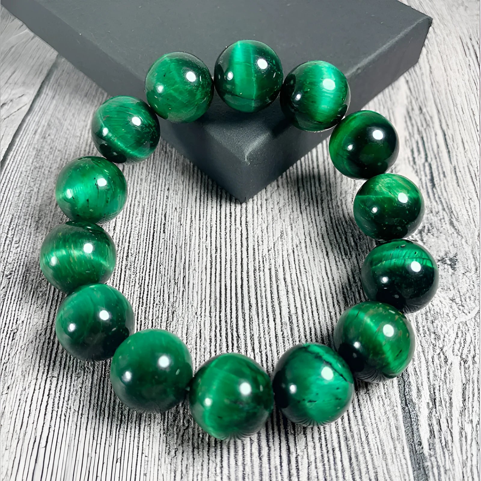 Green tiger eye stone bracelet with polished geometry beads and a sliding knot closure on a wrist.