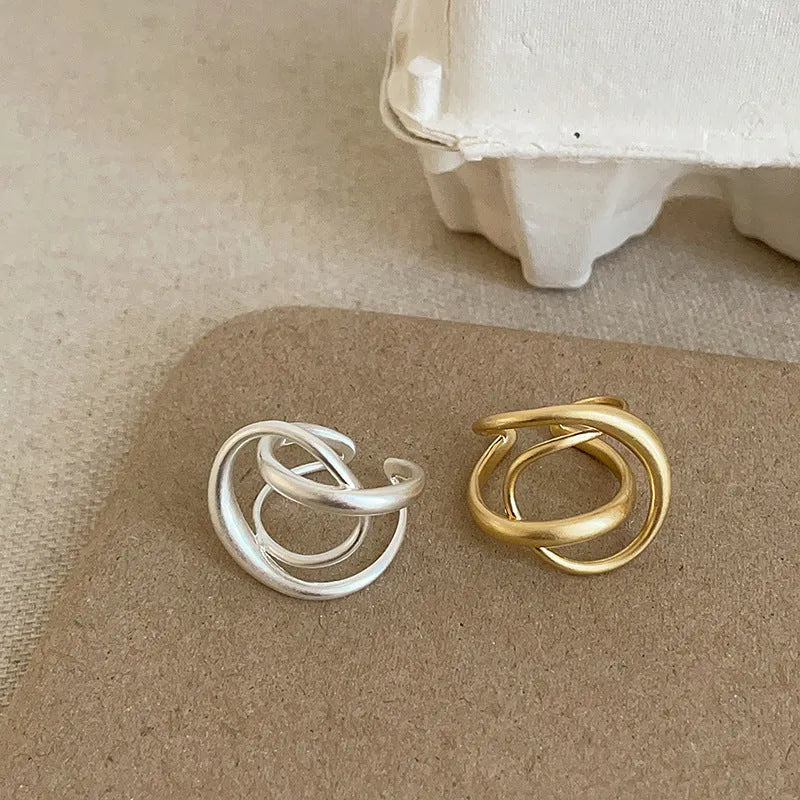 Geometric open ring with three-dimensional interlaced metal design in gold or silver colour