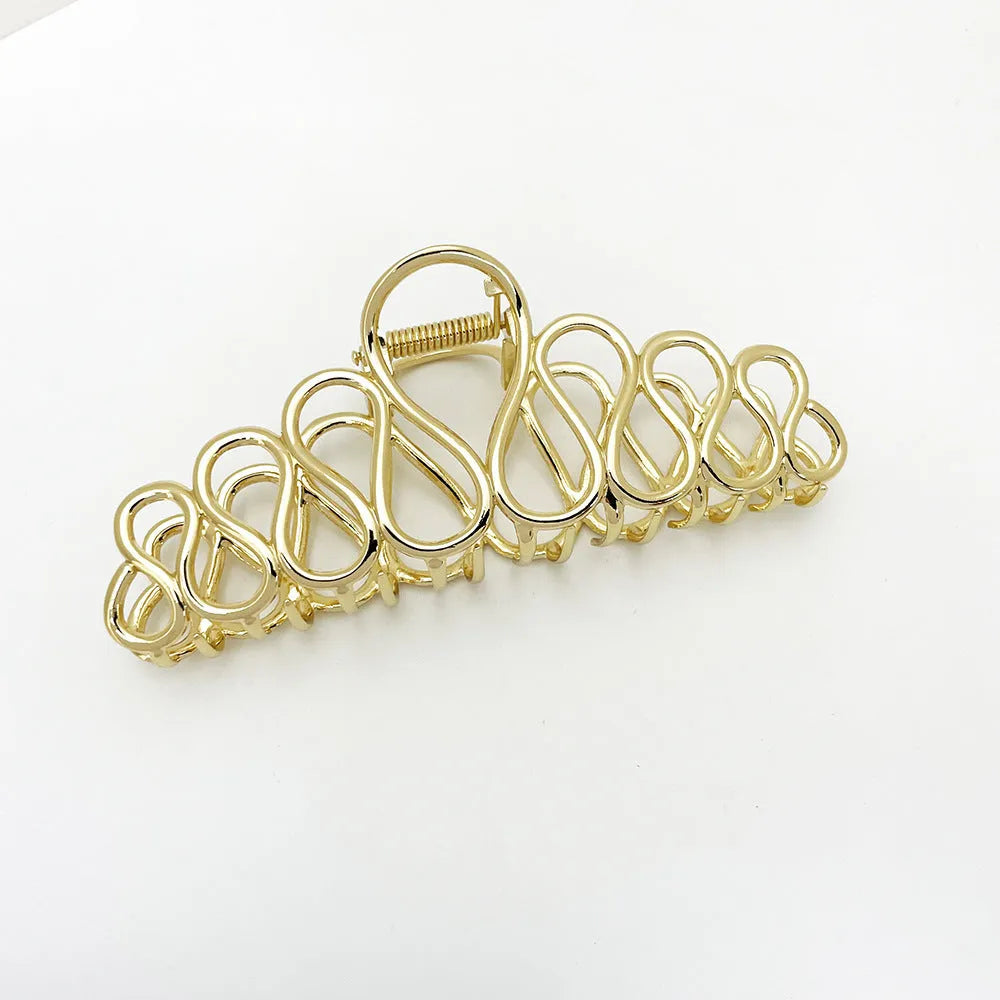 Large gold and silver hair clip with tassel accents for updo styling