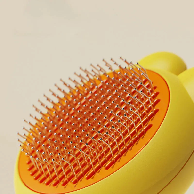 Self-cleaning pet grooming brush with green handle and stainless steel comb, showing the release button.
