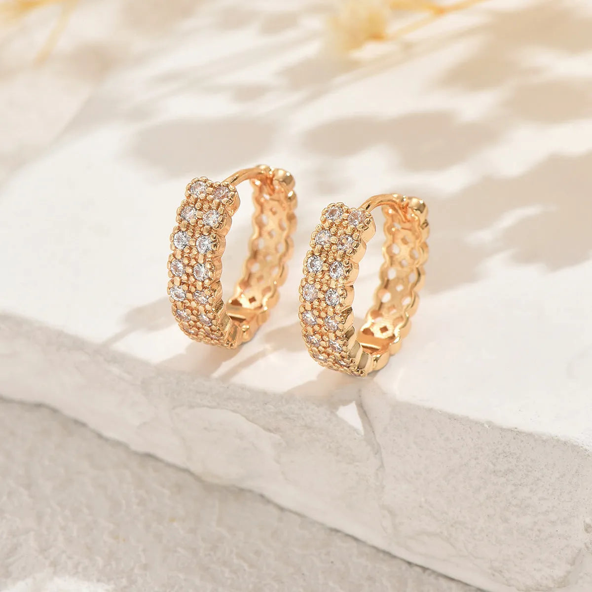 Copper geometric pattern ear studs with round, dot, and ring design elements.