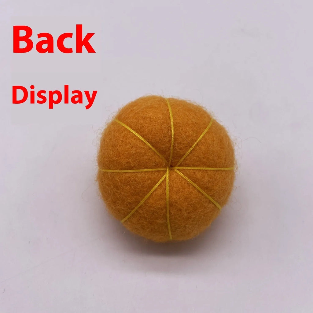Wool felt pumpkin-shaped doll decorations in autumn colours on a neutral background