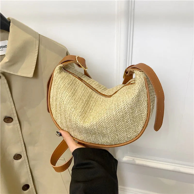Women's knitted straw woven crossbody bag showing woven texture and internal phone compartment
