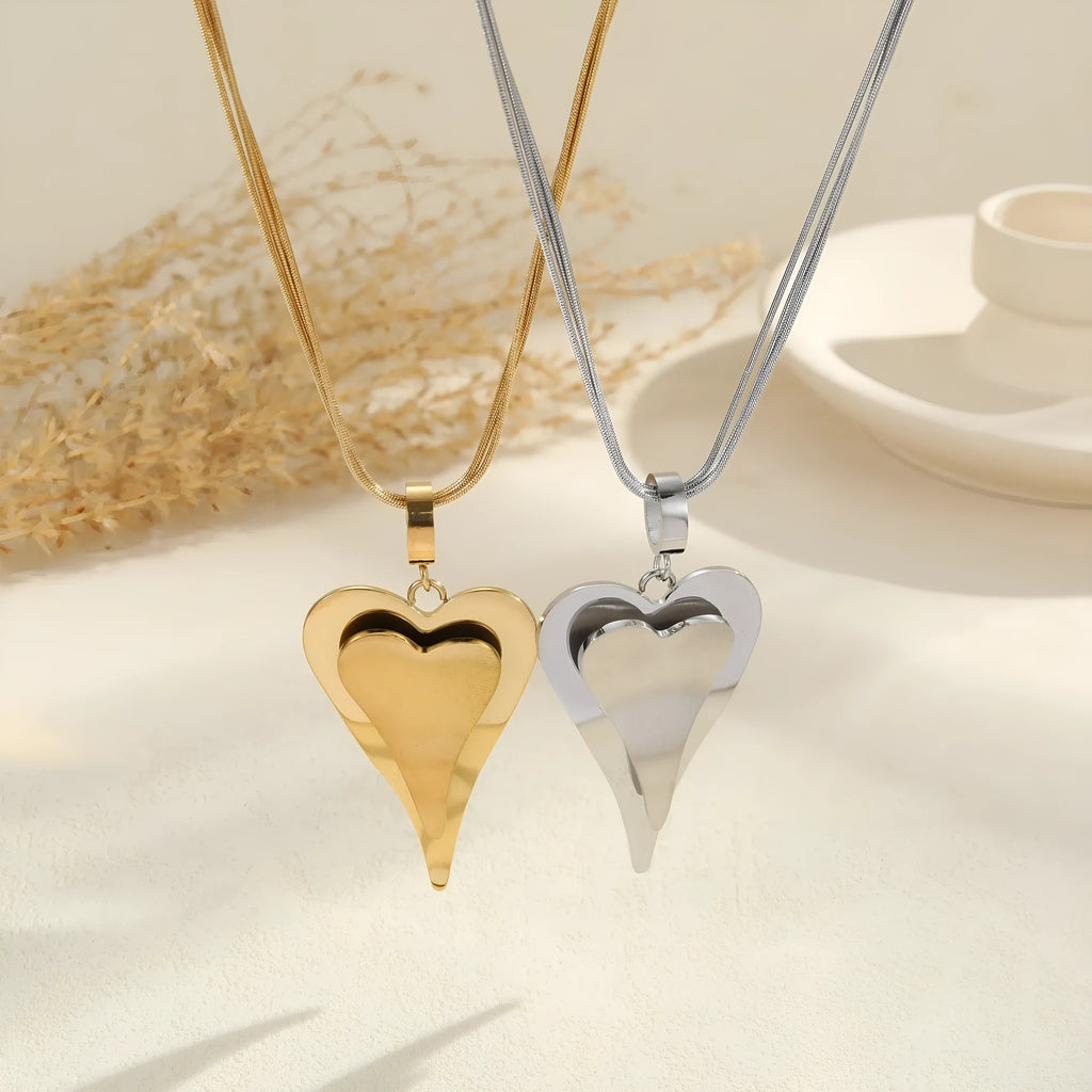 Close-up of a women's stainless steel necklace with a double heart snake bones chain and a geometric pendant.