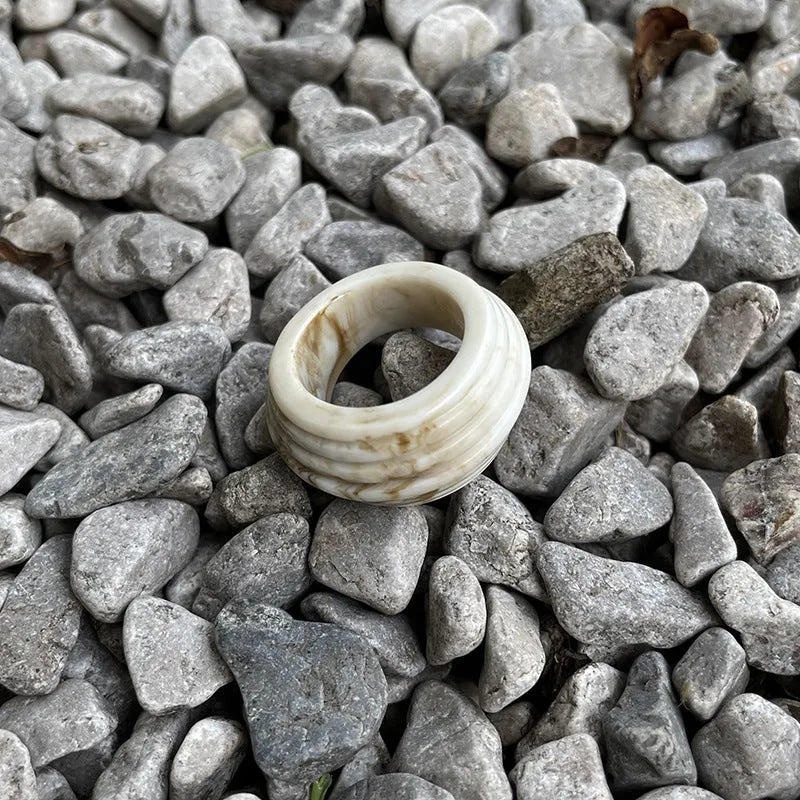 Chinese style irregular geometric resin wide ring in neutral colours on display