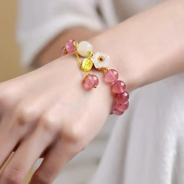 Handmade women's bracelet with strawberry quartz beads and Hetian jade peach blossom details.