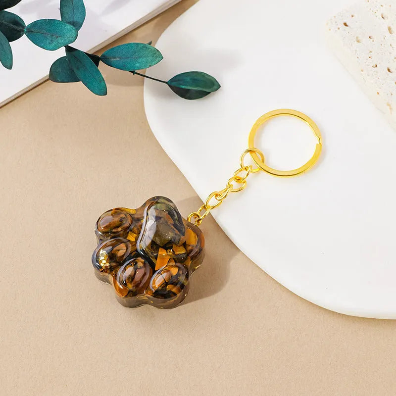 Small natural crystal cat's paw keychain pendant on a metal ring.