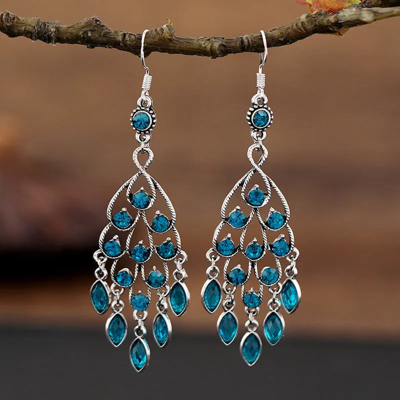 Purple drop-shaped earrings with long fringe detailing, showing retro ethnic style.