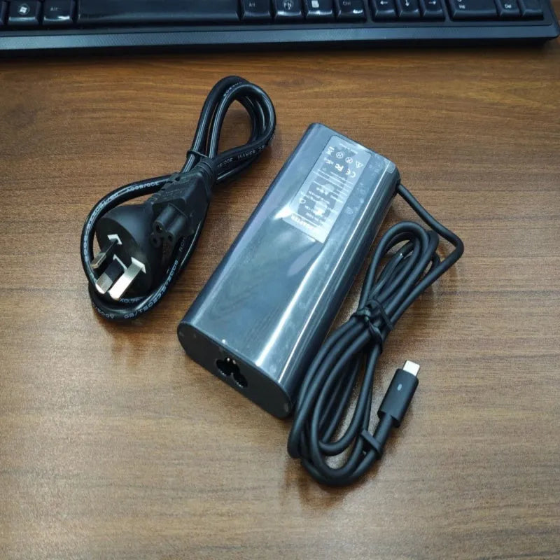 Black 65W USB-C laptop power adapter with set of international plug cords.