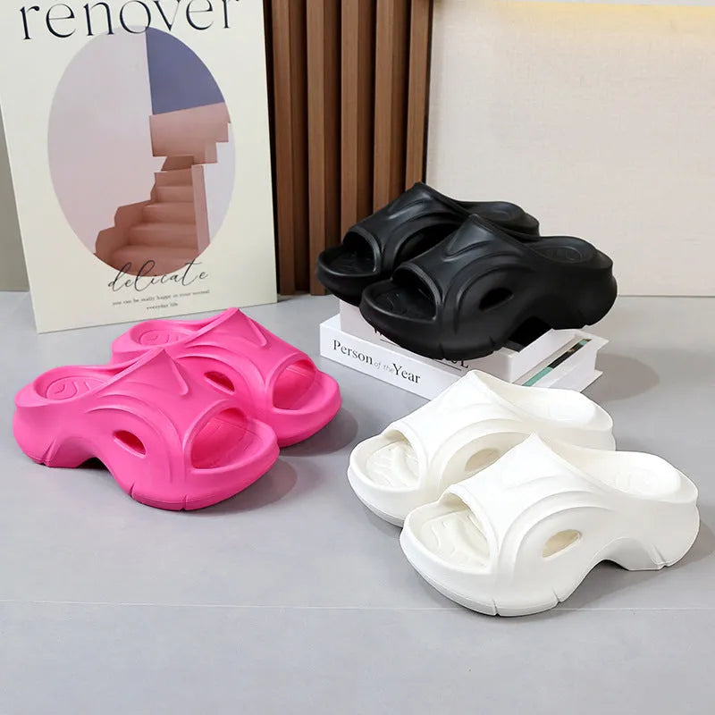 Women's white EVA slippers with a thick sole on a sandy beach background