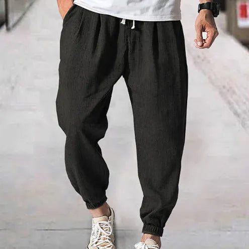 Men's cotton ankle banded trousers in light green colour showing loose fit and summer casual styling