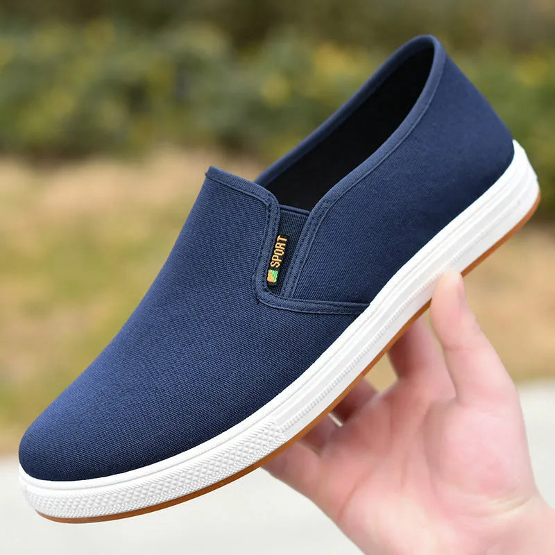 Men's black and blue slip-on canvas shoes with composite soles showing round toe design