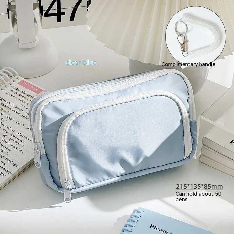 Double-layer pencil case in blue showing internal compartments and a top carry handle