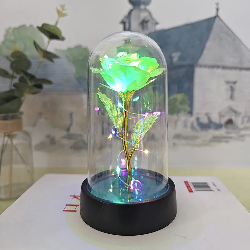 Small decorative night lamp with glass cover, plastic flower, and black base on a pink box.