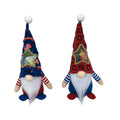 Two cloth Christmas ornaments: a faceless baby doll and a Rudolf candy bag on a red background.