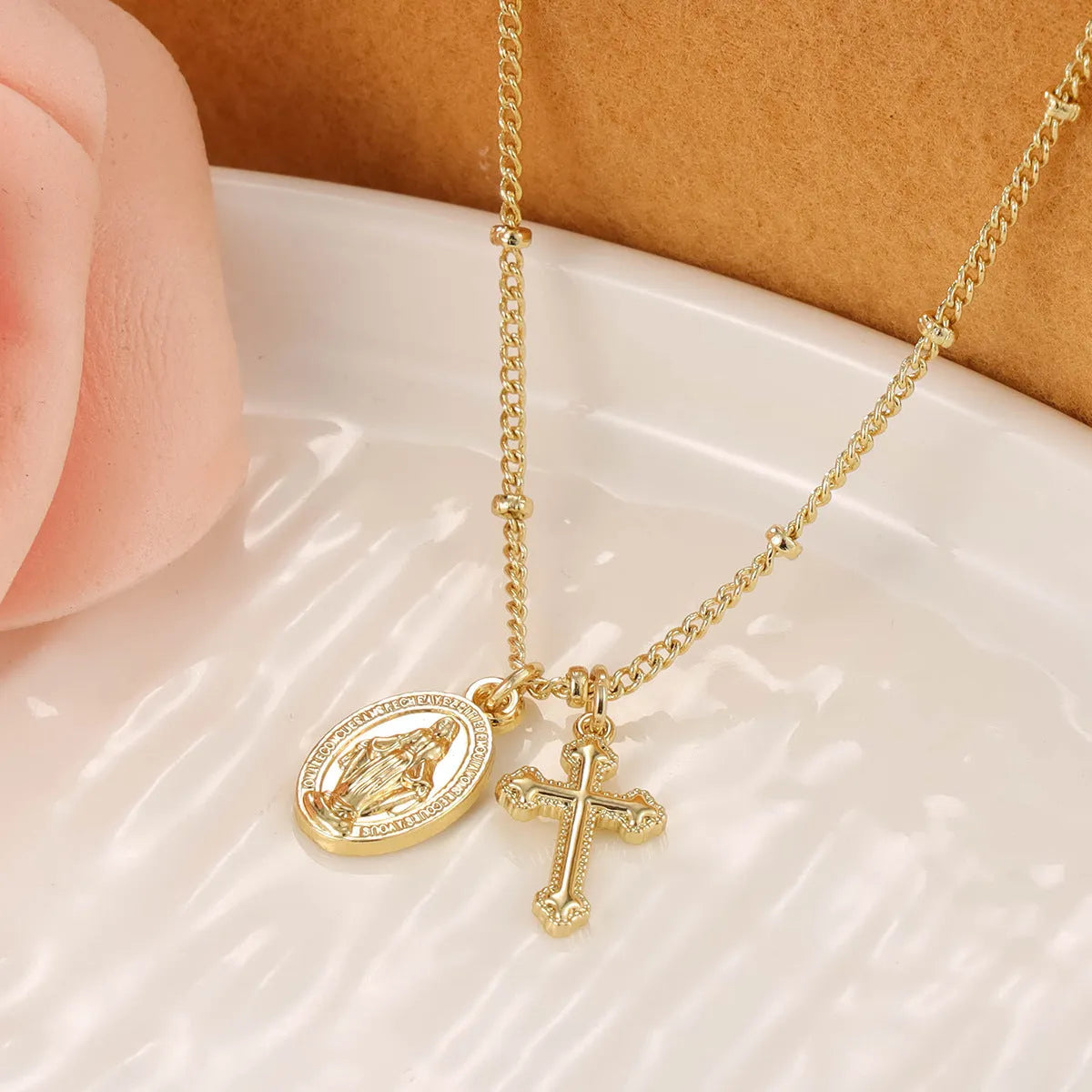 Geometric Cross Virgin Mary pendant necklace in gold on a simple chain.