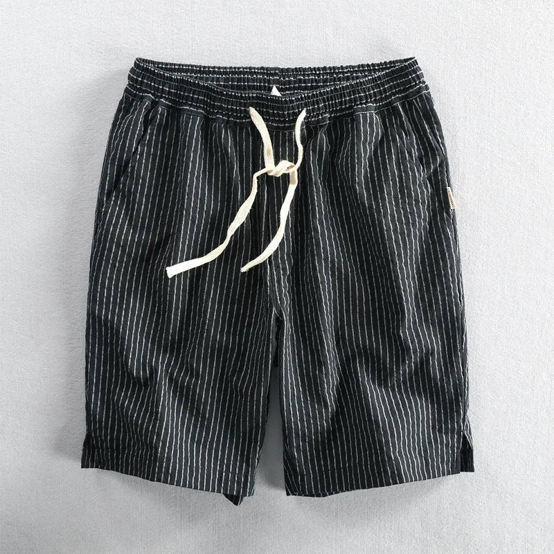 Man wearing black and white striped loose-fit casual cotton shorts with a mid waist.