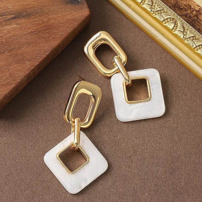 A pair of hollow geometric square earrings with chamfered corners in an electroplated copper finish.