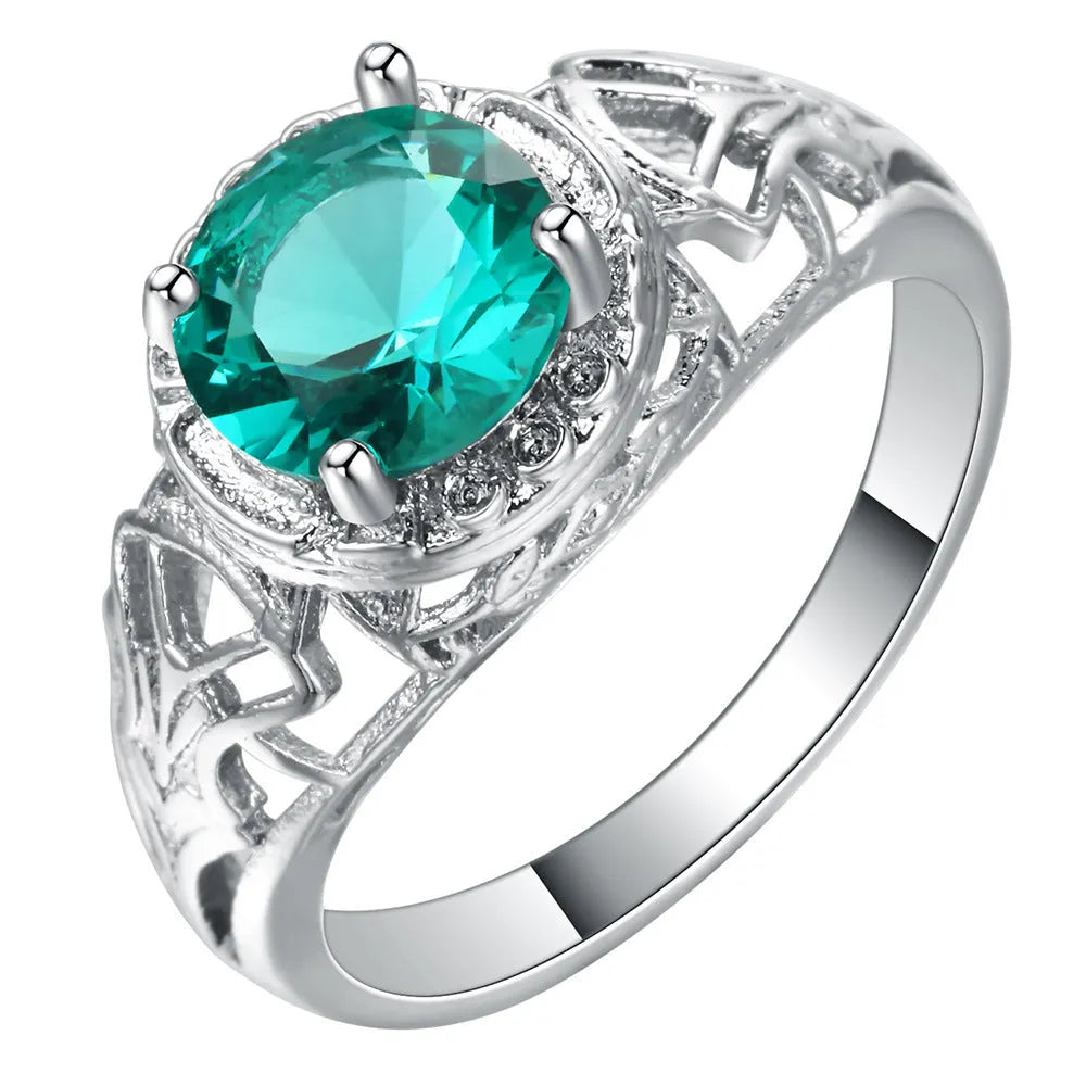 Silver electroplated copper ring with inlaid zircon stone on neutral background