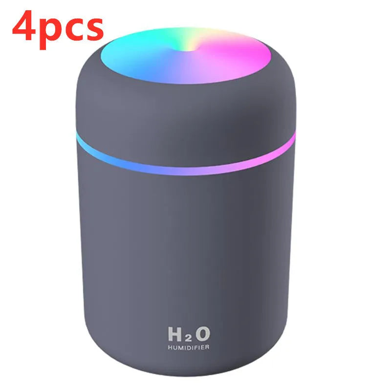 Pink USB desktop humidifier with colourful LED lights and 300ml water tank on wooden desk