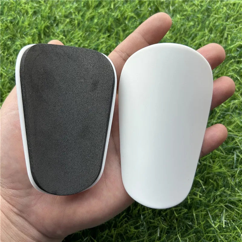 Extra small mini football shin guards measuring 8x5cm in black and white colours