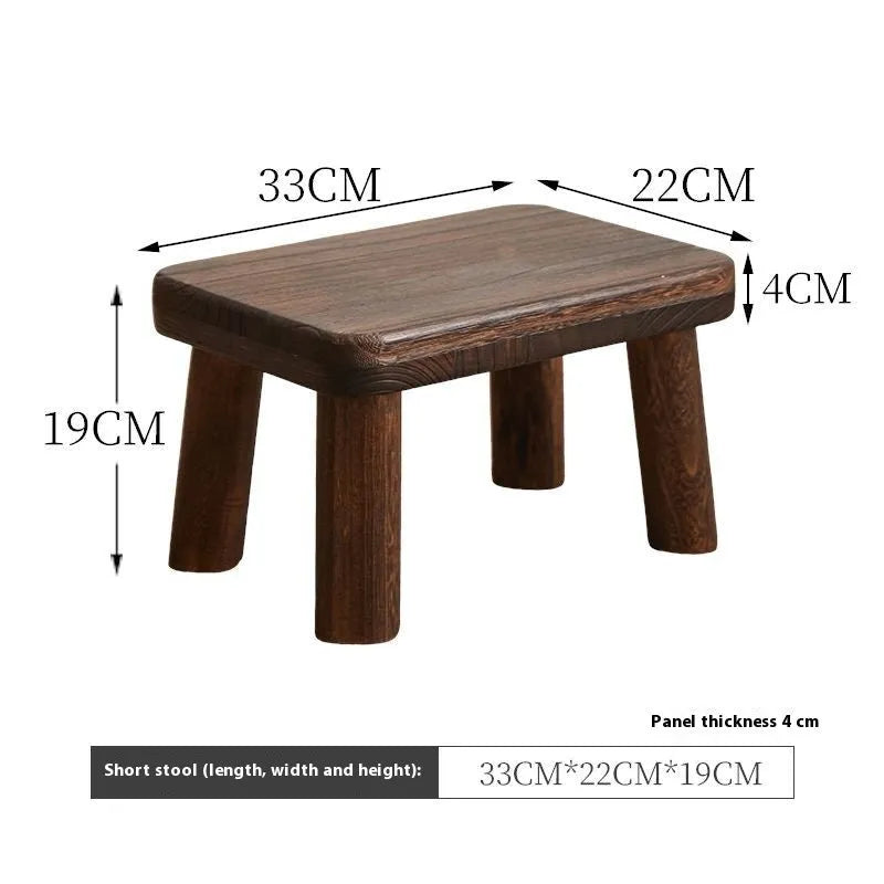 Solid wood shoe changing stool with a distressed rustic finish and sturdy bracket legs.