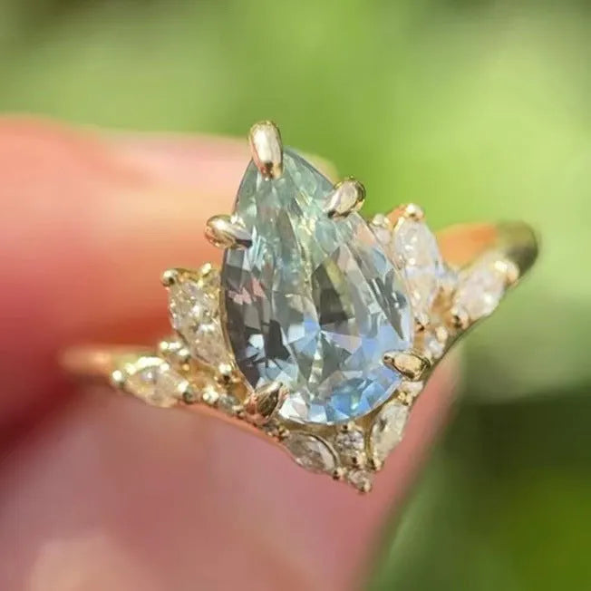 Gold alloy women's floral ring with blue crystal diamond inlay, side view