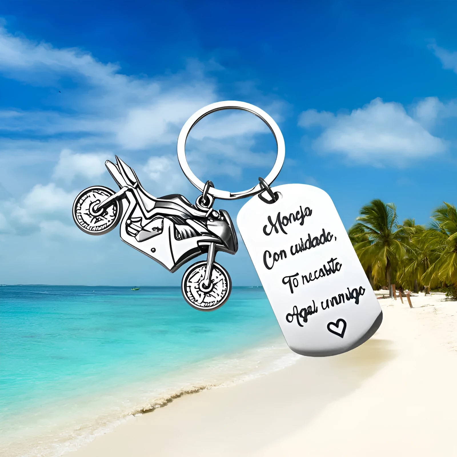 Stainless steel key ring with etched motorcycle design next to a grey flannel drawstring bag.