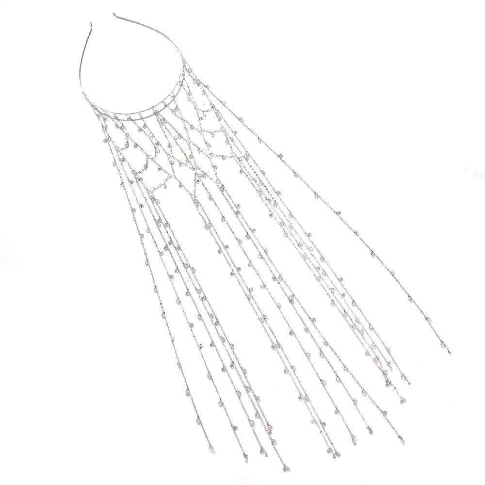 Gold rhinestone and mesh hairband with a long tassel, laid flat on a dark surface.