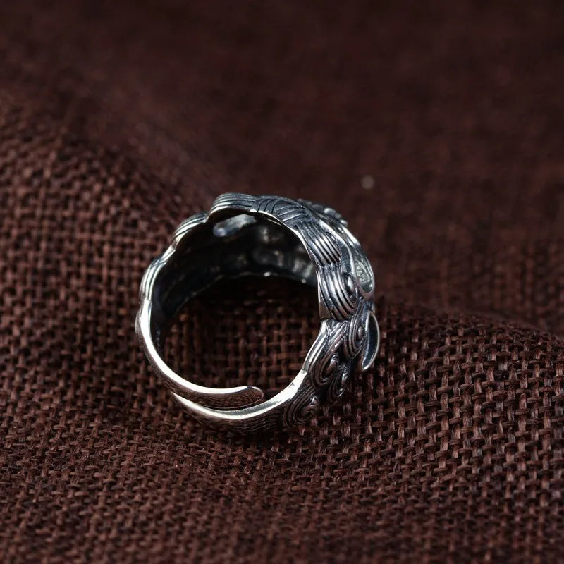 Silver open style diamond ring with a detailed jibeast and animal zodiac pattern.